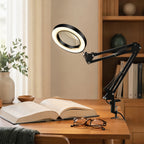 LED-loeplamp op een bureau naast een open boek en een leesbril