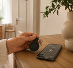 Bluetooth-sleutelvinder aan sleutelbos naast smartphone — warme Seniorslim huisstijl